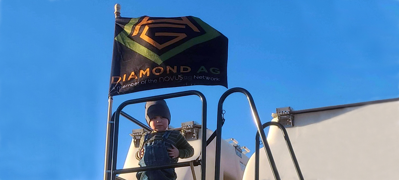 child on stairway under Diamond Ag flag